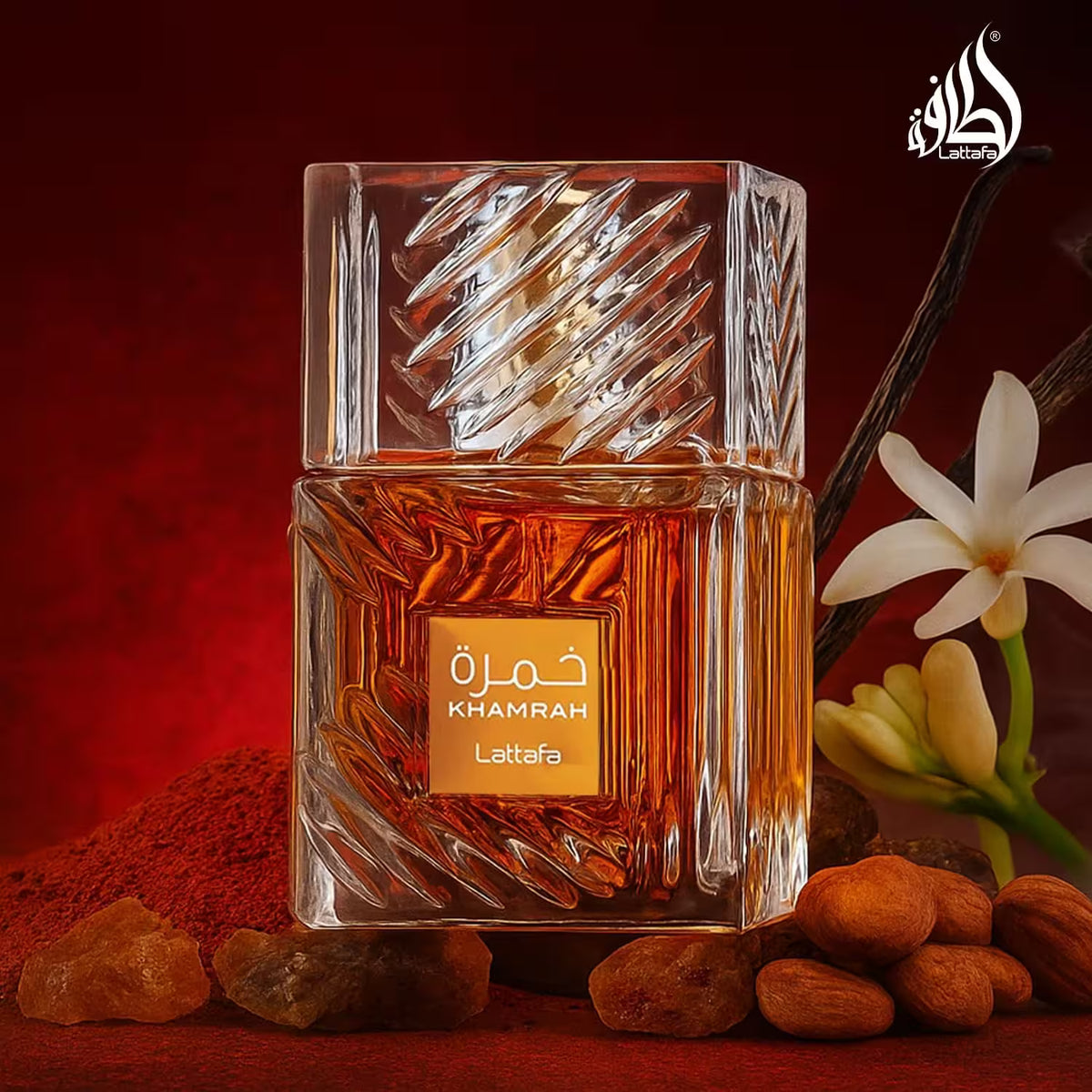 Khamrah Lattaqa perfume bottle with almonds and flowers on a red background