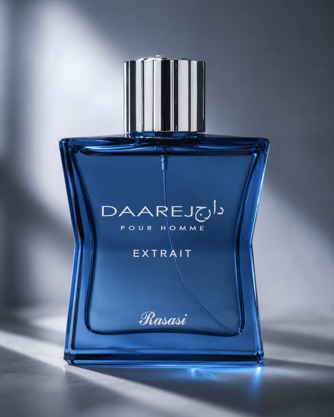A blue glass fragrance bottle labeled 'DAAREJ POUR HOMME EXTRAIT' with 'Rasasi' at the bottom, topped with a metallic silver cap, set against a dark gray background with dramatic light streaks.