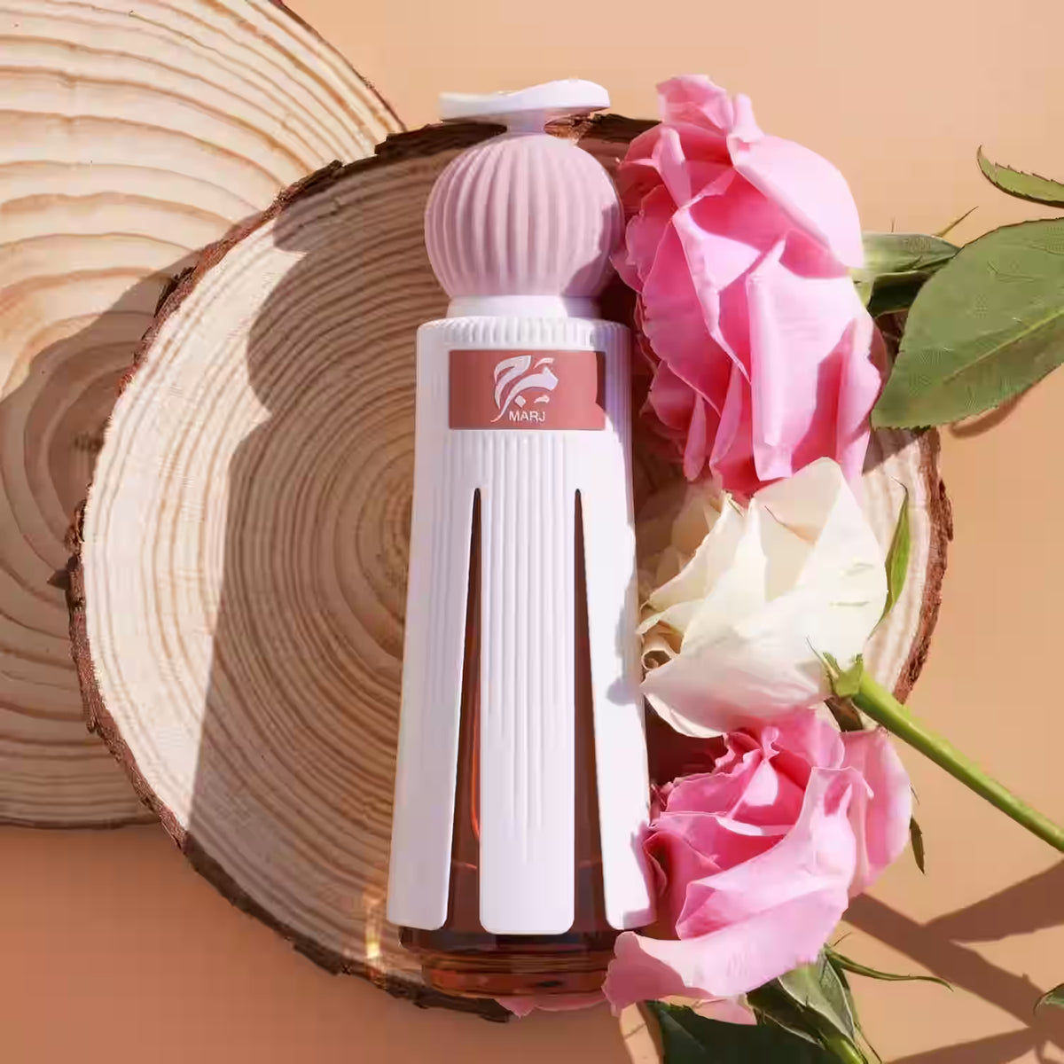 White perfume bottle with pink flowers on a wooden surface