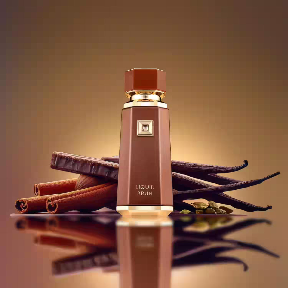 A faceted brown perfume bottle labeled 'LIQUID BRUN' stands upright on a reflective surface, styled with cinnamon sticks, vanilla beans, and green beans against a warm brown gradient background.